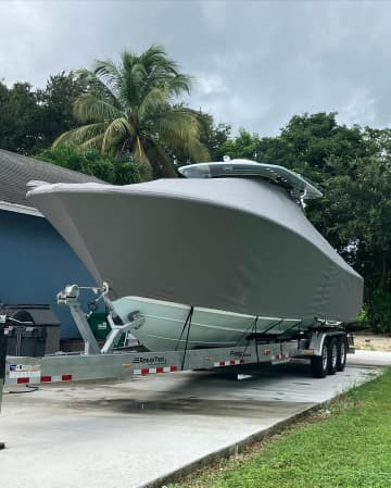 Light grey travel cover over a center console boat on a trailer