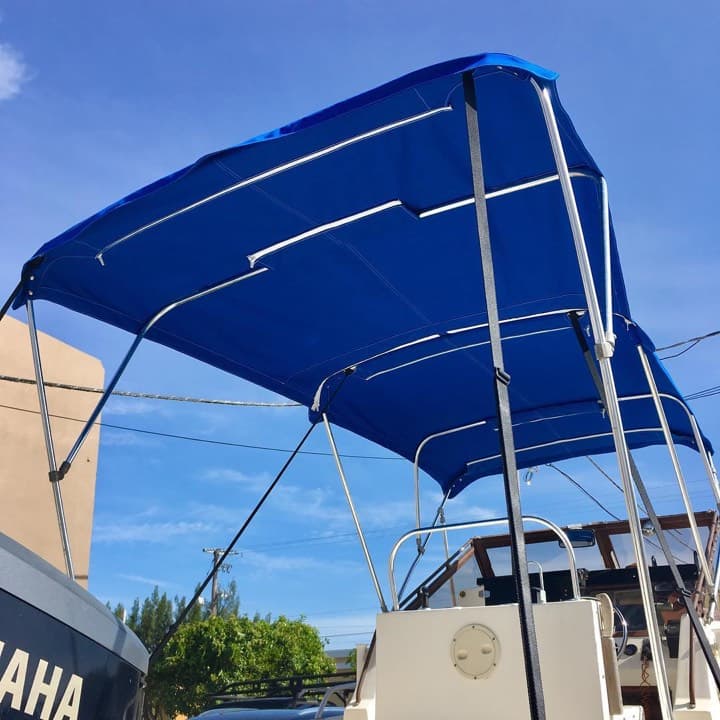 Royal pacific blue Sunbrella bimini top with white zippers on a stainless frame over a 23-foot Mako