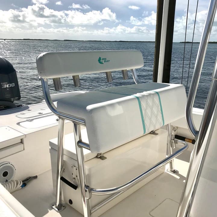 White leaning-post bench cushion with a teal diamond-stitched accent on a Contender 25 Bay center console over open water