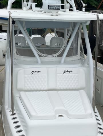 Boat cockpit with white quilted transom cushions and helm seating
