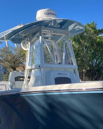 White T-top with radar dome over the helm of a navy blue bay boat